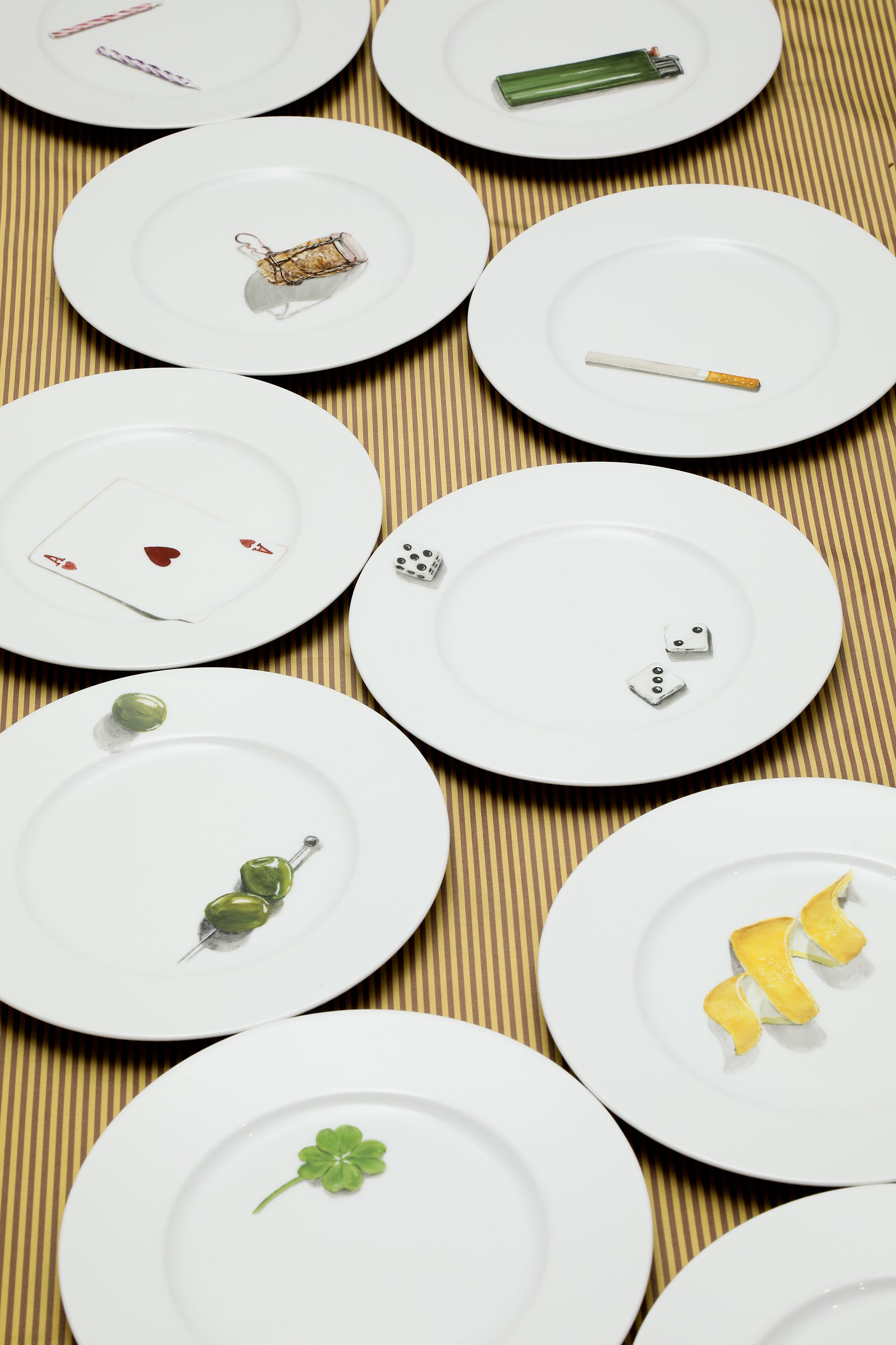 White plates with small food items arranged on a textured surface